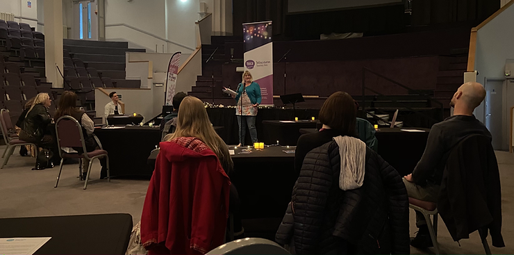 the author standing up telling her story in a socially distanced  Touch Network storytelling event