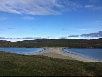 A sand bar causeway that looks like a beach and its mirror image,