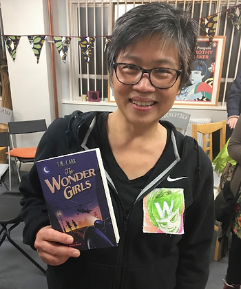 Children's author holding a copy of The Wonder Girls and wearing a fabric W badgeCandy Gourlay