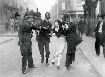 A young woman struggling against arrest by 2 uniformed police during The Battle of Cable Street